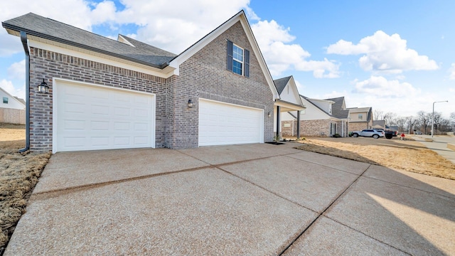 view of property exterior featuring concrete driveway, brick siding, and a shingled roof