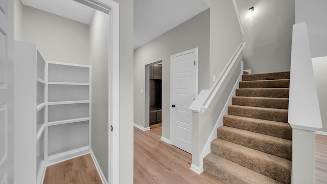 staircase with wood finished floors and baseboards