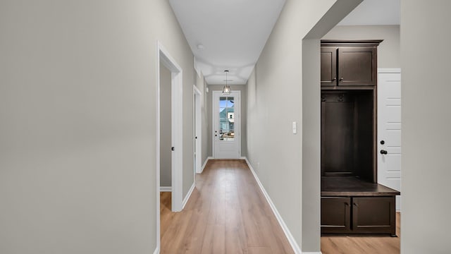 hallway with light wood-style flooring and baseboards