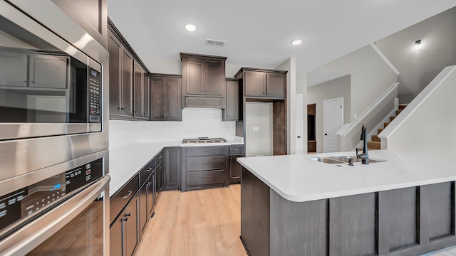 kitchen featuring visible vents, stainless steel appliances, a sink, and light countertops