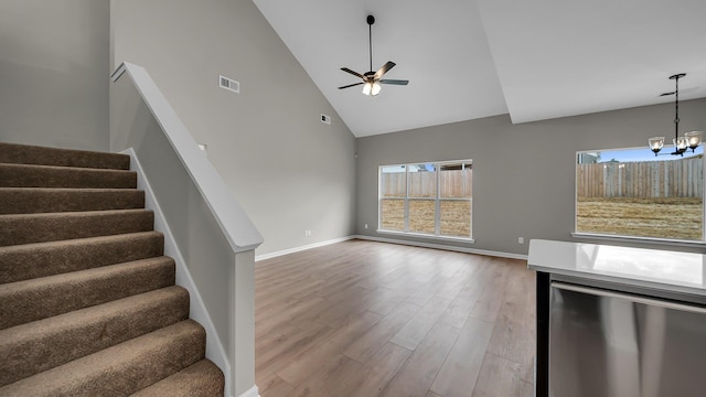 interior space featuring visible vents, wood finished floors, high vaulted ceiling, baseboards, and ceiling fan with notable chandelier