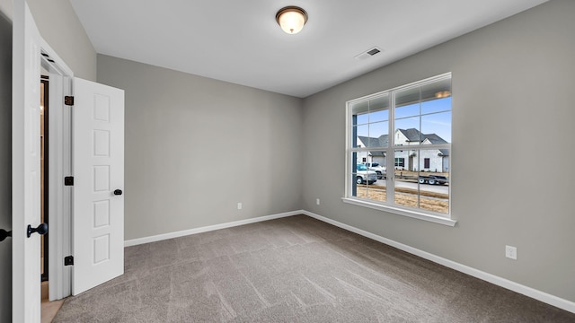 spare room featuring carpet, baseboards, and visible vents