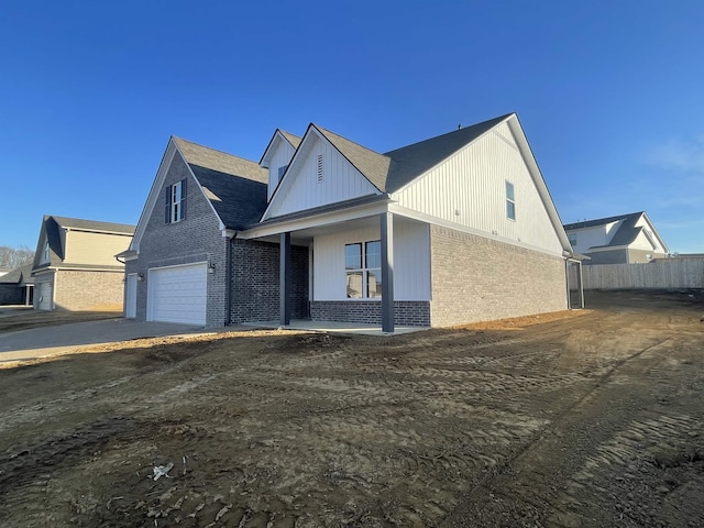 view of front of property with a garage, brick siding, and fence