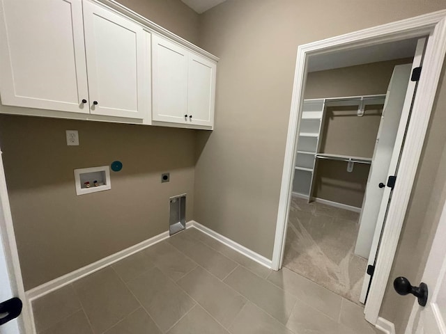 washroom with electric dryer hookup, washer hookup, light tile patterned floors, and cabinets