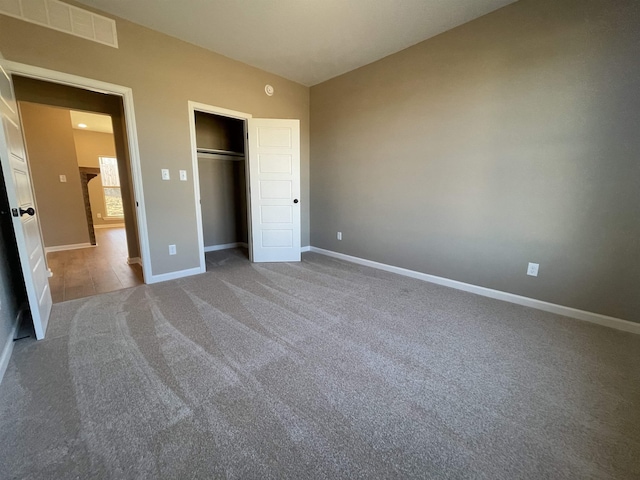 unfurnished bedroom featuring vaulted ceiling, a closet, and carpet