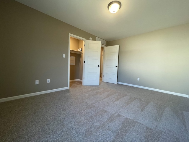 unfurnished bedroom with a walk in closet and carpet floors