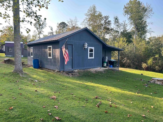 view of side of property with a yard and an outdoor structure