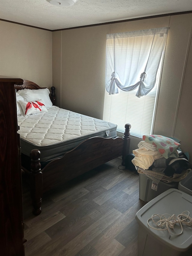 bedroom with a textured ceiling and dark hardwood / wood-style floors