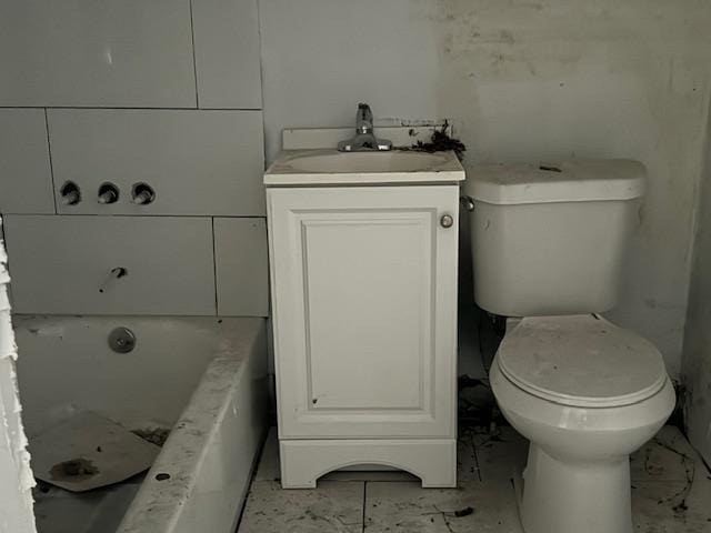 bathroom featuring a bath, vanity, and toilet