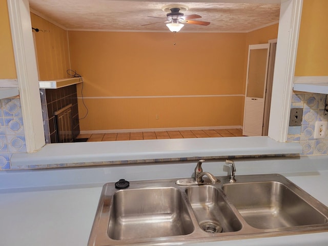 kitchen with ceiling fan, a textured ceiling, wooden walls, and sink