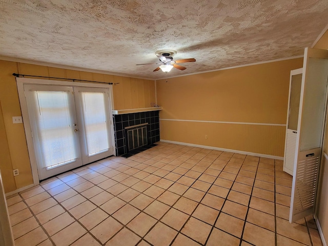 unfurnished living room featuring french doors, light tile patterned floors, and a textured ceiling