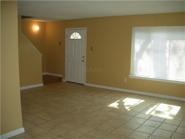 foyer entrance featuring light tile patterned floors and a healthy amount of sunlight