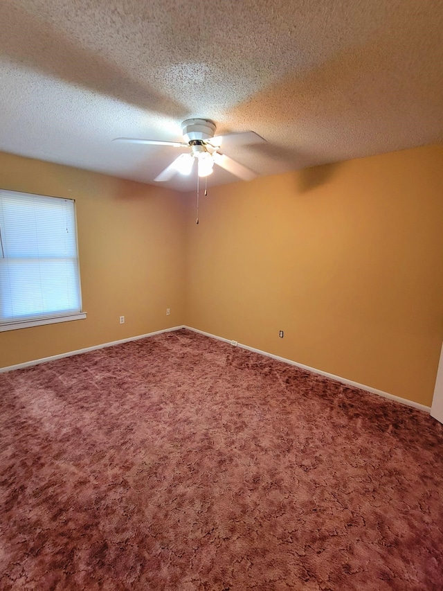 spare room featuring carpet floors, ceiling fan, and a textured ceiling