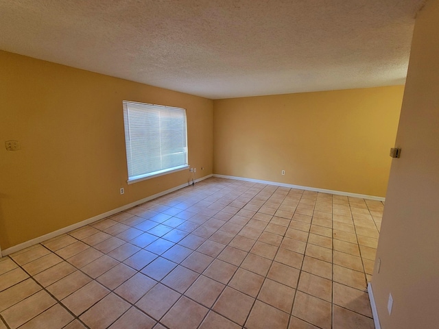 tiled empty room with a textured ceiling