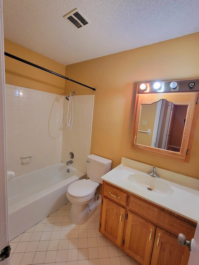 full bathroom with vanity, tiled shower / bath combo, tile patterned flooring, toilet, and a textured ceiling