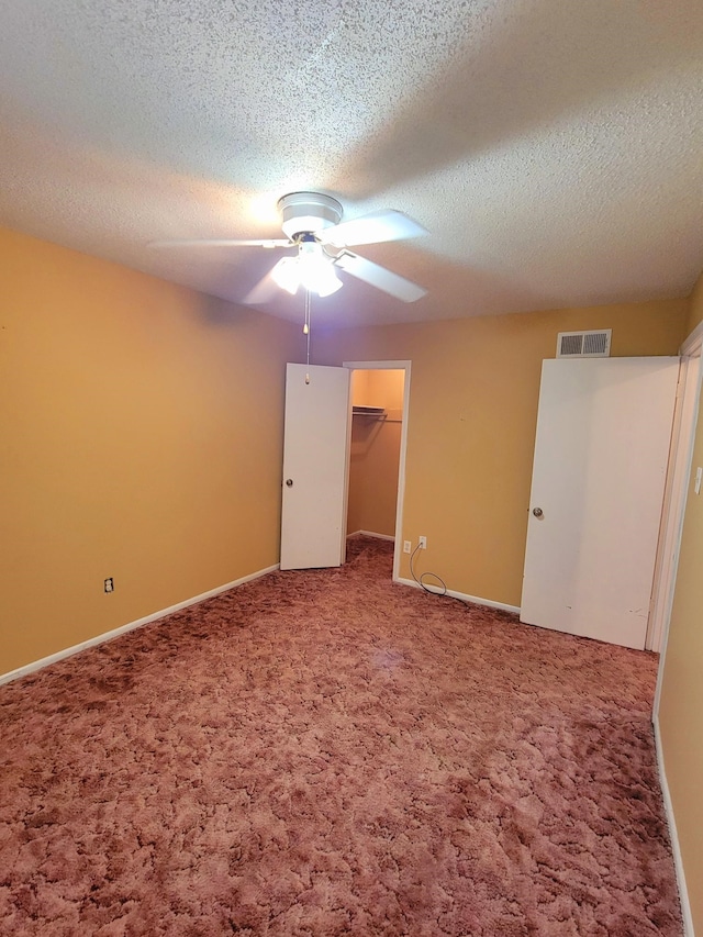 unfurnished bedroom featuring ceiling fan, a textured ceiling, and carpet floors