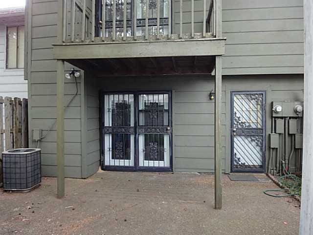 view of exterior entry with central air condition unit and a balcony