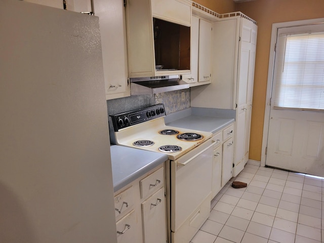 kitchen with light tile patterned flooring, white appliances, and white cabinetry