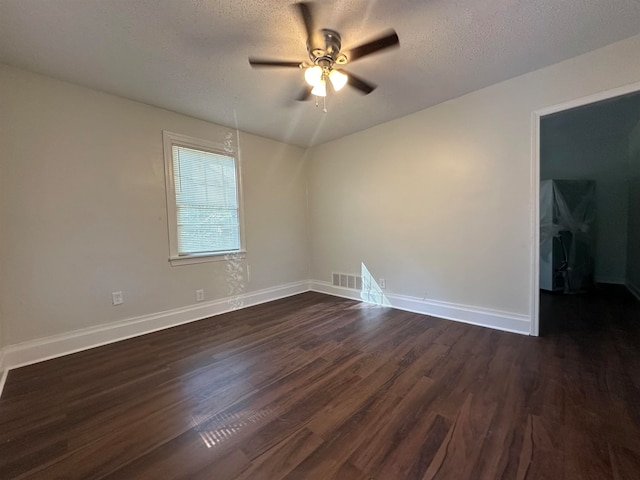 spare room featuring ceiling fan, dark wood-type flooring, and a textured ceiling