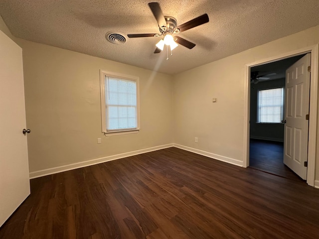 spare room featuring ceiling fan, a textured ceiling, and dark wood-type flooring