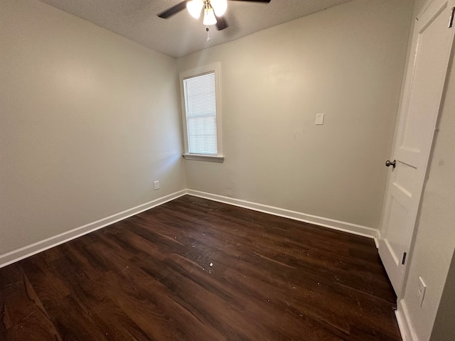 empty room featuring dark hardwood / wood-style flooring, a textured ceiling, and ceiling fan