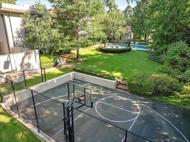 view of sport court featuring a yard and a fenced in pool