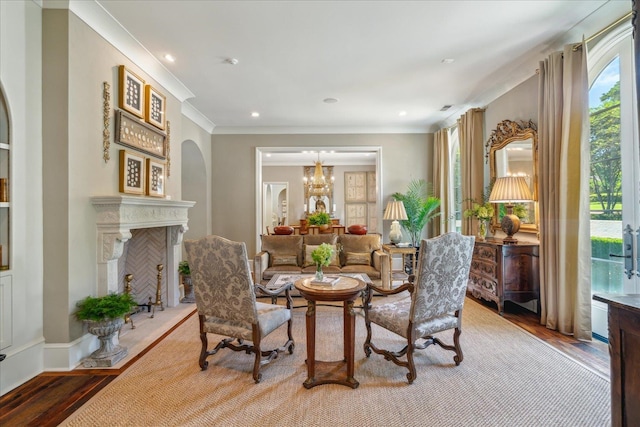 sitting room featuring ornamental molding, hardwood / wood-style flooring, and a notable chandelier