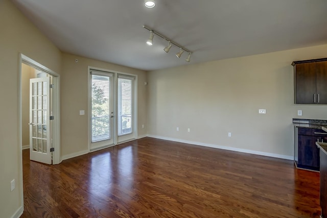 interior space with track lighting and dark hardwood / wood-style flooring