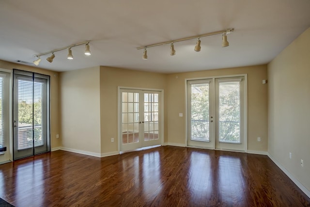 unfurnished room with dark hardwood / wood-style flooring, french doors, and rail lighting