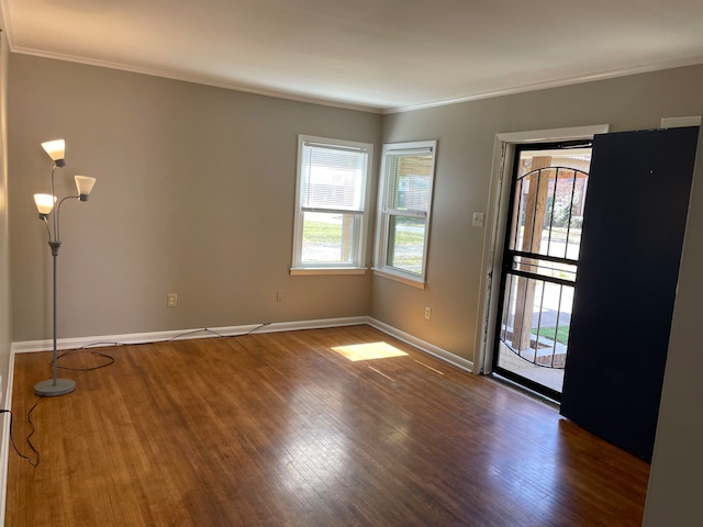 spare room featuring ornamental molding and dark wood-type flooring