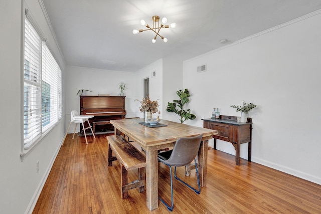 dining room featuring ornamental molding, a chandelier, and hardwood / wood-style flooring