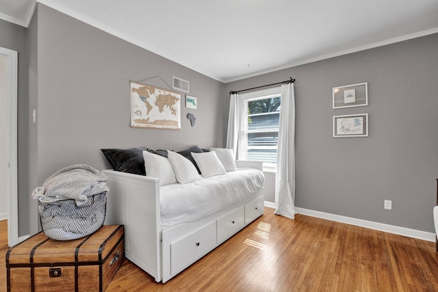 bedroom with crown molding and light hardwood / wood-style flooring