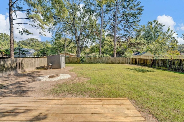 view of yard featuring a wooden deck and a storage unit