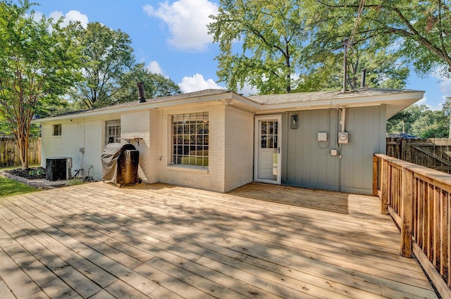 rear view of house with a wooden deck and central AC unit