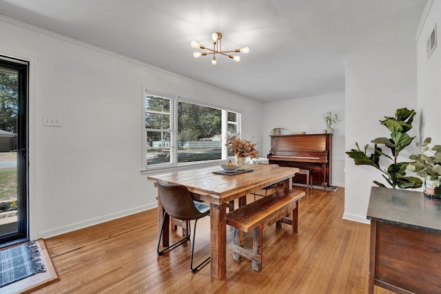 dining area featuring ornamental molding, plenty of natural light, light hardwood / wood-style floors, and a chandelier