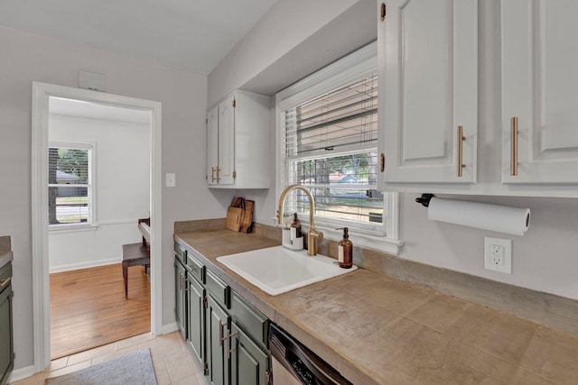 kitchen featuring light hardwood / wood-style flooring, sink, white cabinetry, and a healthy amount of sunlight