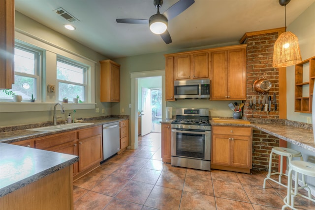 kitchen featuring ceiling fan, sink, decorative light fixtures, appliances with stainless steel finishes, and tile patterned floors