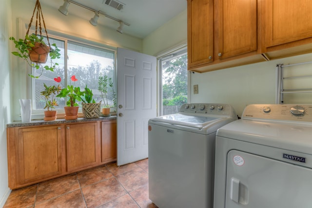 laundry area with rail lighting, washing machine and dryer, cabinets, and light tile patterned floors