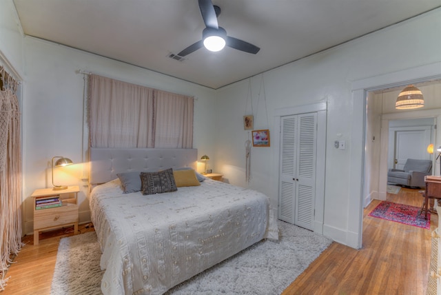 bedroom featuring a closet, light wood-type flooring, and ceiling fan