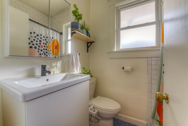 bathroom with walk in shower, vanity, and toilet