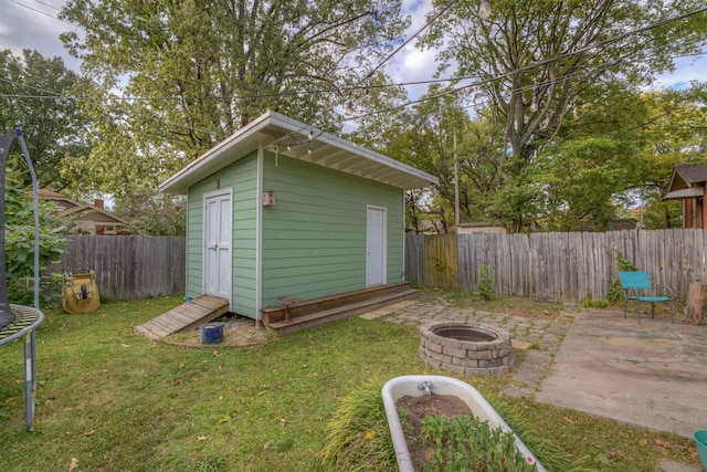 view of outbuilding with a fire pit and a yard