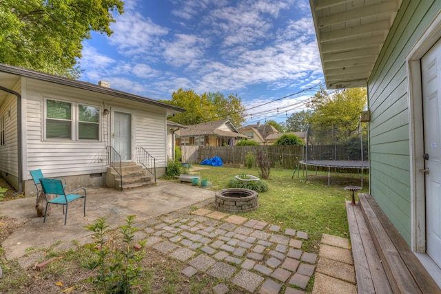 view of patio / terrace featuring a trampoline and a fire pit