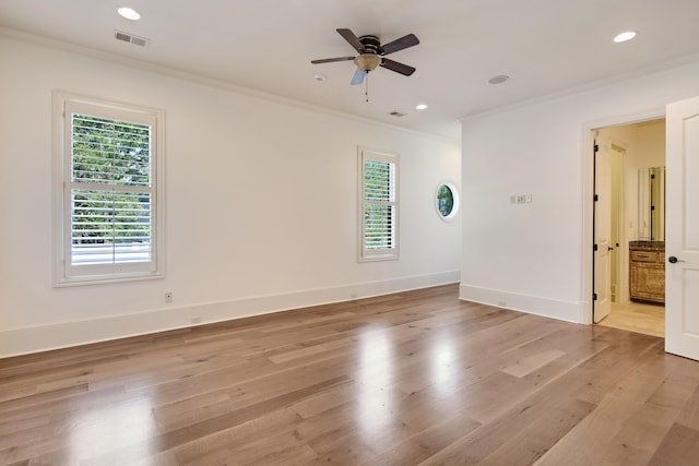 empty room featuring ornamental molding, light hardwood / wood-style flooring, and a healthy amount of sunlight