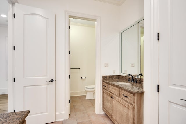 bathroom with tile patterned flooring, ornamental molding, vanity, and toilet