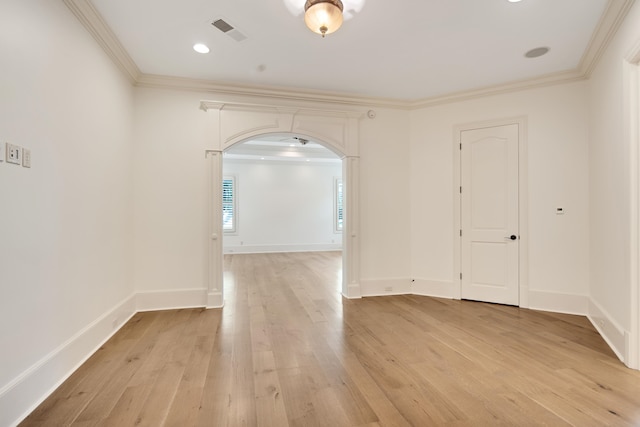 empty room featuring crown molding and light hardwood / wood-style floors