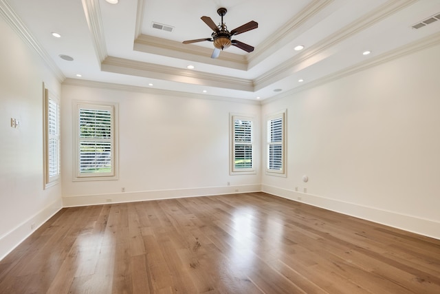 unfurnished room with a raised ceiling, crown molding, light hardwood / wood-style flooring, and ceiling fan