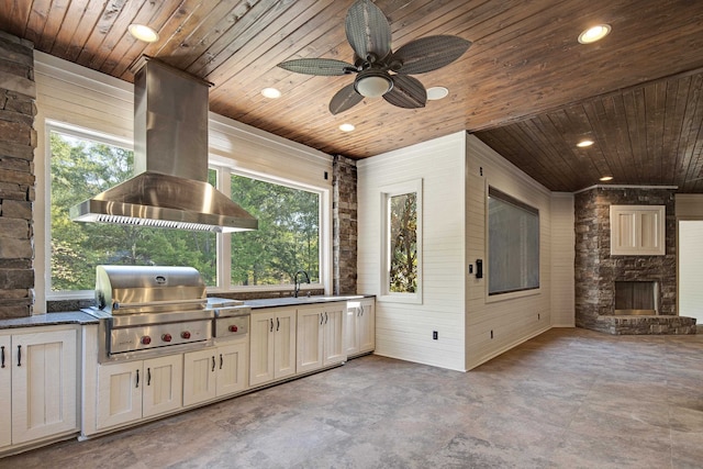 view of patio featuring an outdoor kitchen, an outdoor stone fireplace, ceiling fan, and grilling area