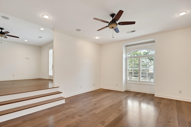 spare room featuring wood-type flooring, ornamental molding, and ceiling fan