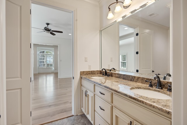 bathroom featuring crown molding, ceiling fan, vanity, and wood-type flooring