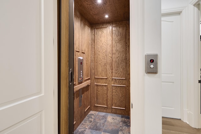 interior details featuring elevator and wood-type flooring